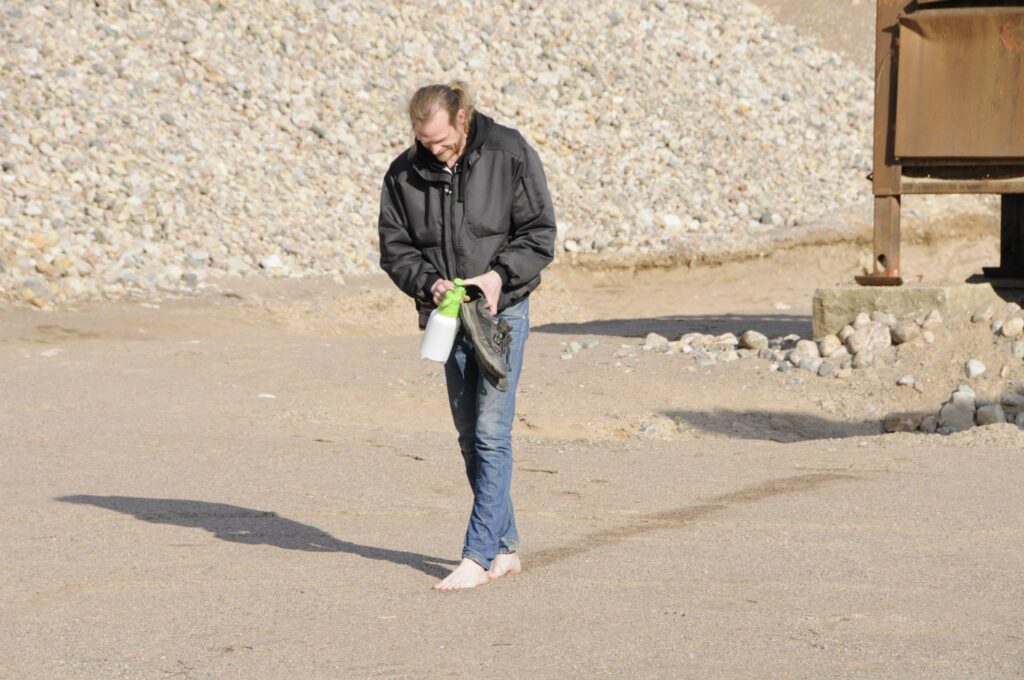 Person som går barfota och lägger spår till sin hund.
